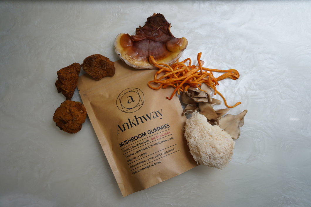 Assorted mushrooms next to a bag of Ankhway mushroom gummies